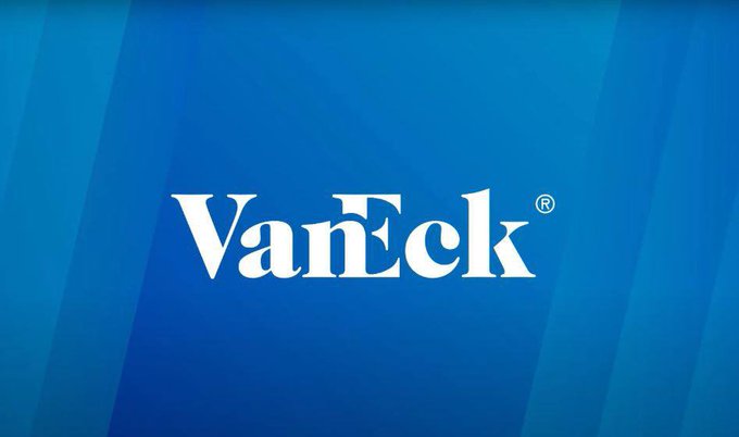 In this image, there is a white logo consisting of the word "VanEck" written in all capital letters positioned centrally within a blue background that mimics a watermark design resembling waves in the ocean with blue and green colors. The text also reads "BREAKING: $200B VanEck launches first US spot $BNB ETF, allowing US investors' direct access to BNB", which is somewhat related to an investment opportunity in the VanEck ETF that has recently launched for US investors. This image appears to be part of a larger graphic or advertisement related to VanEck and its product offerings.