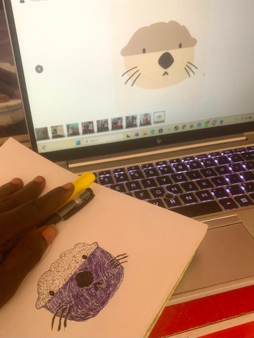 A child draws a purple otter on paper using a reference image of a cartoon otter displayed on an HP laptop screen.