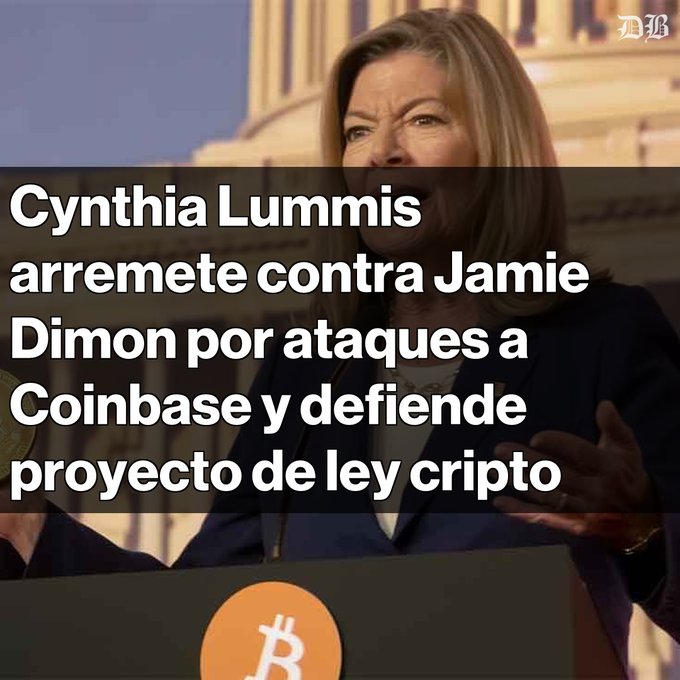 The image features a woman, Cynthia Lummis, standing at a podium with her hands outstretched as if she's giving a speech or addressing an audience. The text in the image reads "Tensión cripto: Cynthia Lummis responde a Jamie Dimon La senadora critica fuertemente al CEO de JPMorgan por sus ataques a Coinbase y el CLARITY Act". This suggests that the woman is discussing the recent news about a CEO of a company, possibly related to cryptocurrency or blockchain technology. The image also includes an orange Bitcoin symbol in the bottom right corner and a name "Cynthia Lummis" written above her head.