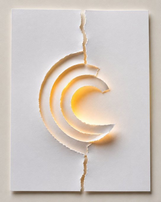 A minimalist white paper artwork featuring torn concentric circular shapes revealing warm golden-orange tones beneath, with a torn vertical line running through the center.