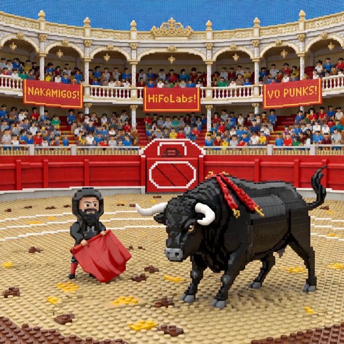 A LEGO-style bullring scene depicts a matador waving a red cape at a charging black bull, with stadium banners reading "NAKAMIGOS!", "HiFoLabs!", and "VO PUNKS!" displayed to a crowd of spectators, visually celebrating the "Nakamigos" bull run referenced in the post.
