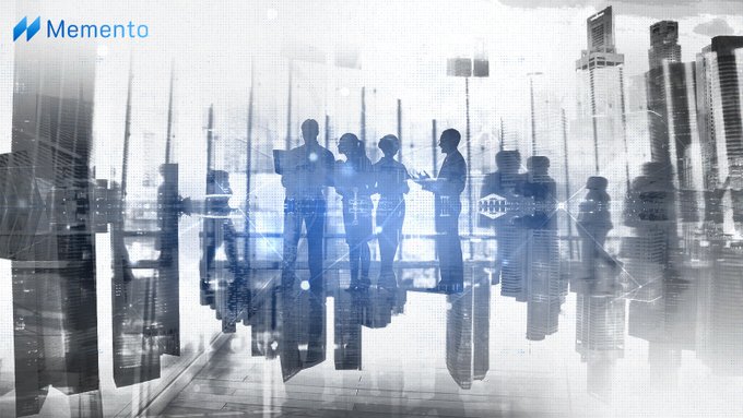 A blue-toned stock image of business people silhouetted in a modern office with city skyscrapers visible in the background, branded with the 'Memento' logo in the top left corner.