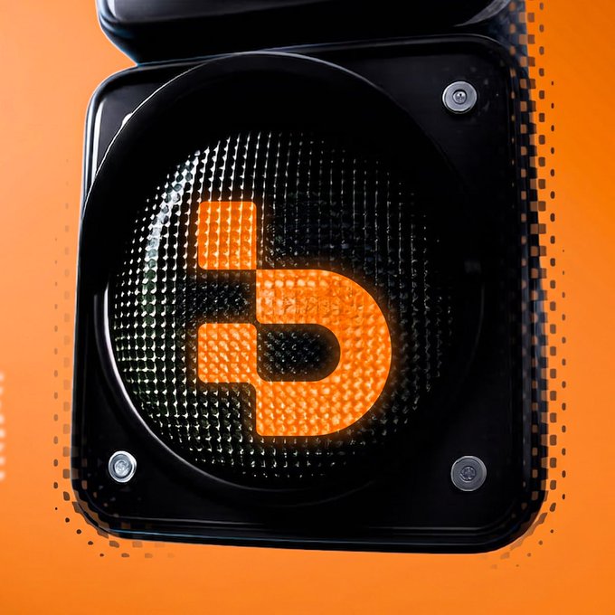 An illuminated orange Djed (Djed) cryptocurrency logo displayed on a circular speaker against an orange background.