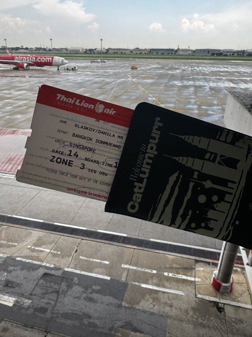 A boarding pass for Thai Lion Air from Bangkok Don Mueang (DMK) to Singapore, dated 14 Sep, held up against the view of an Air Asia plane on the tarmac at the airport.