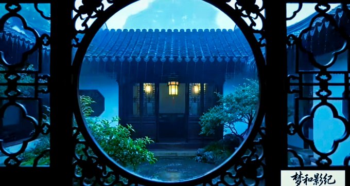 A moody, blue-tinted scene shows a traditional Chinese building viewed through an ornate circular window frame (a moon gate) in the rain, with Chinese text '梦和影纪' in the bottom right corner.