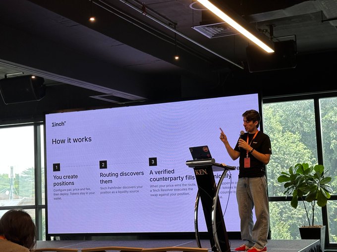 A man gives a presentation on a stage about a service called '1inch', explaining a 3-step process on a large screen.