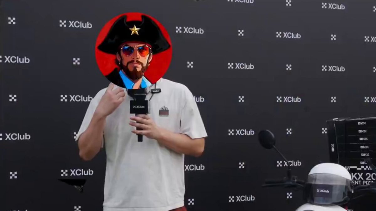 The image features a man wearing a pirate hat, sunglasses, and holding a microphone while standing in front of a black background with white text that reads "XClub". The man appears to be making a funny face or engaging in some sort of humorous activity related to the XClub logo.