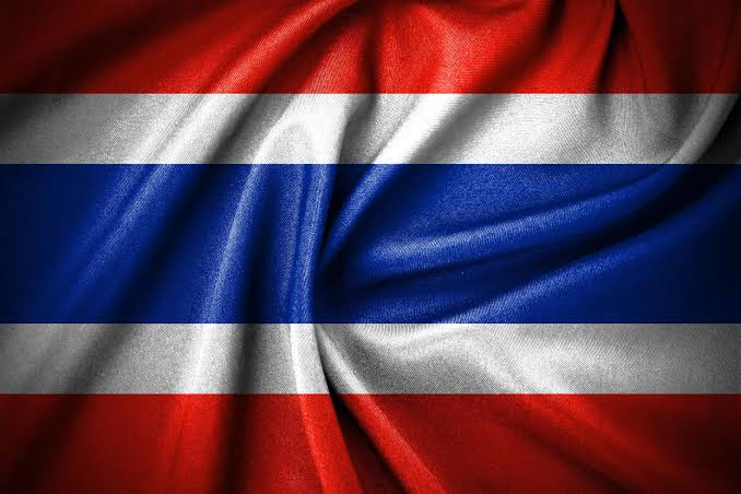 The image displays the flag of Thailand, featuring its iconic red, white, and blue horizontal stripes rendered with a silky, flowing texture. It directly relates to the post by visually representing Thailand, where the government has just announced a 0% capital gains tax exemption for crypto trades conducted through licensed exchanges.