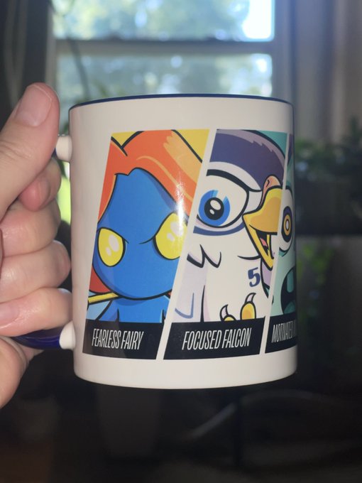 A hand holds a white VeeFriends mug displaying character panels labeled "FEARLESS FAIRY" and "FOCUSED FALCON," connecting to the post's shoutout to @veefriends and @garyvee as part of a morning "GM" (good morning) routine.