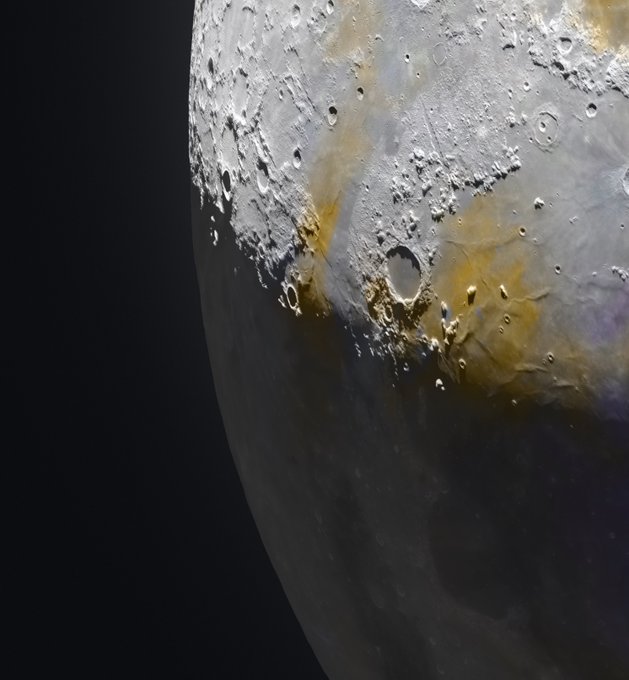 A detailed photograph of the moon's surface showing craters, with golden/yellow coloration along the terminator line against the dark sky.