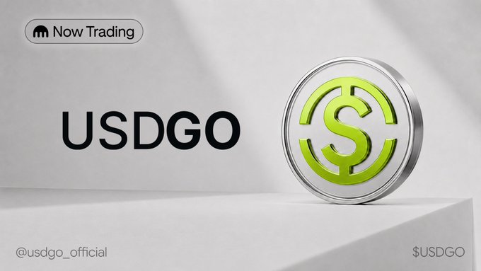 Promotional graphic for $USDGO featuring a large green dollar sign coin, with "Now Trading" badge and "usdgo_official" handle, advertising the live launch of the US dollar-backed stablecoin on Kraken Pro.