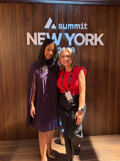 Two women pose together in front of a wooden wall displaying the 'Summit New York 2026' logo.