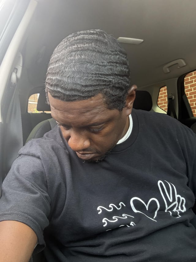 A man takes a selfie inside a car, showing off his freshly done 360 waves hairstyle. The "54 on the 18th" likely refers to his age and a notable achievement, drawing a playful comparison to the r/Hedera subreddit community.