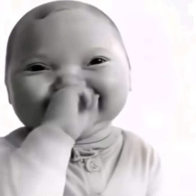 A black-and-white close-up of a smiling baby with their hand near their mouth, capturing a joyful, mischievous expression. The image humorously evokes the eager, excited anticipation described in the post about the upcoming "Trenches airdrop" event in two hours, suggesting the community is on the verge of seeing something incredible ("godly cinema").