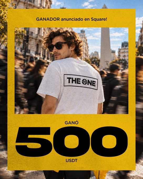 A young man wearing sunglasses and a "THE ONE" t-shirt stands with his back turned in a crowded city street, beneath yellow banners announcing "GANADOR anunciado en Square!" (Winner announced on Square!) and revealing that he "GANÓ 500 USDT" (Won 500 USDT), directly tying into Binance Square's promotional reveal of the contest winner.