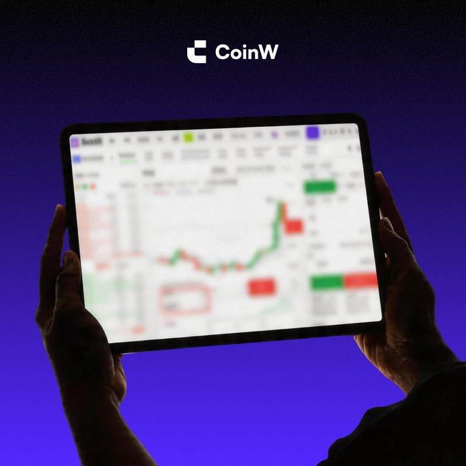 The image shows a person holding a tablet displaying a blurred cryptocurrency trading chart with green and red candlesticks, with the CoinW logo prominently featured at the top against a deep blue background. This visual aligns with the post about a new tool that helps traders anticipate the direction of upcoming candles on charts.

The tablet also displays exchange metrics such as 24h volume of approximately $2.94 billion and last price of 108,241.53.