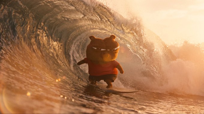 A small animated bear-like character wearing an orange shirt surfs on a surfboard inside a large curling wave at sunset.