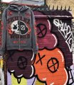 A collection of graffiti-tagged skateboards with a disc golf disc resting on top, displaying various colorful designs and stickers.
