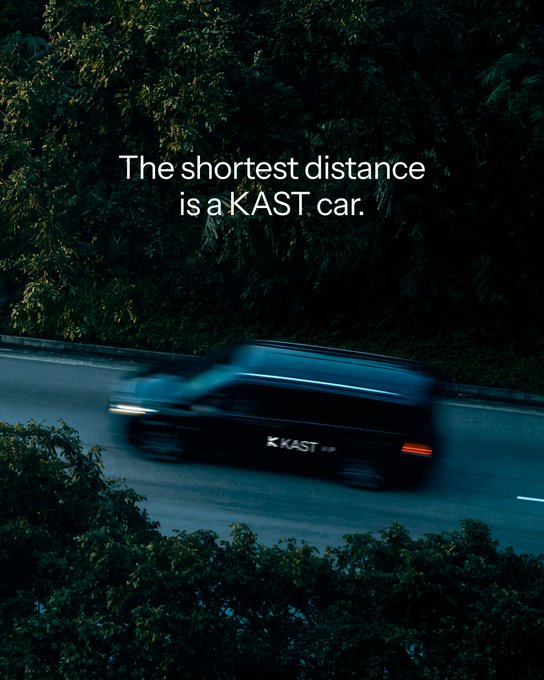An advertisement showing a dark van driving on a tree-lined road, with the text 'The shortest distance is a KAST car.' and the 'KAST' logo on the vehicle.