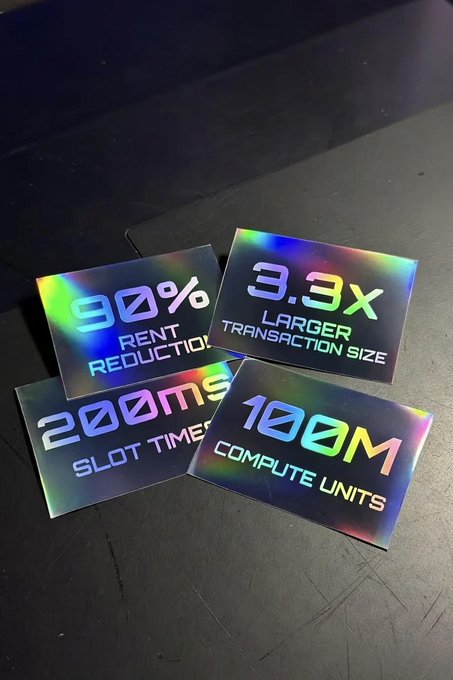 Four holographic placards display key blockchain performance metrics: "90% Rent Reduction," "3.3x Larger Transaction Size," "200ms Slot Time," and "100M Compute Units," visually emphasizing the bold performance claims behind the "BIG." announcement.