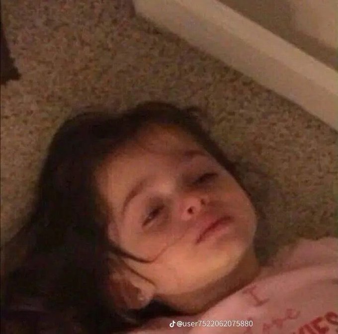 A low-resolution, blurry video still shows a young girl lying down, with a TikTok watermark '@user7522062075880' in the bottom right corner.