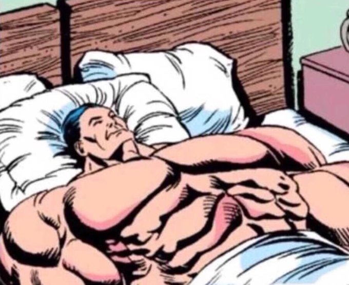 A comic-style illustration depicts a heavily muscled man sleeping peacefully in a bed with white pillows. He has blue hair and is covered by a white blanket.