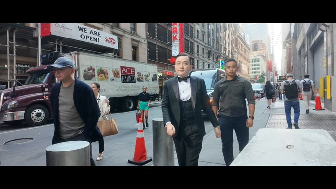 The image shows three men walking down a city street with tall buildings around them. One man is wearing a suit and tie, while another is dressed more casually. The third person appears to be carrying a backpack. In the background, there are several trucks parked along the street, indicating that this scene takes place in an urban environment.

The image also contains text about Justin Sun's thoughts on ecosystem scaling and how it relates to technology. This suggests that the photo might have been taken during a conversation or event related to blockchain technology or the development of new ecosystems for its application. The focus on timing, execution, and global accessibility in the context of ecosystem scaling is an important aspect of the discussion surrounding Justin Sun's ideas.