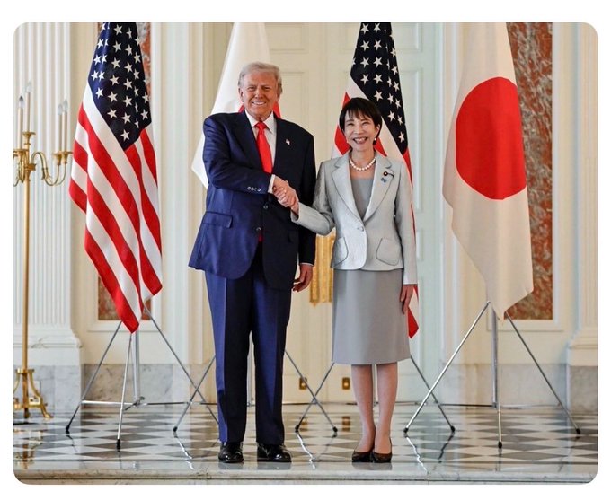 Japan's Prime Minister Sanae Takaichi shakes hands with President Trump in front of U.S. and Japanese flags, posing for a formal bilateral photo at what appears to be a White House meeting. The image corresponds to the post's reference to Takaichi meeting with Trump, which the caption suggests was followed by a private discussion after the public press was dismissed.