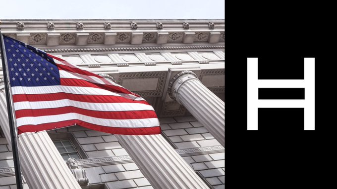 A large letter "H" on a black background is displayed next to an American flag waving in front of a stately government building with classical columns, visually linking the Hedera (HBAR) brand to U.S. State Department imagery.