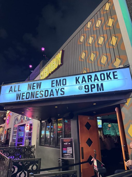 A nighttime photo of an 'EMO KARAOKE' venue marquee advertising 'ALL NEW EMO KARAOKE WEDNESDAYS @ 9PM'.