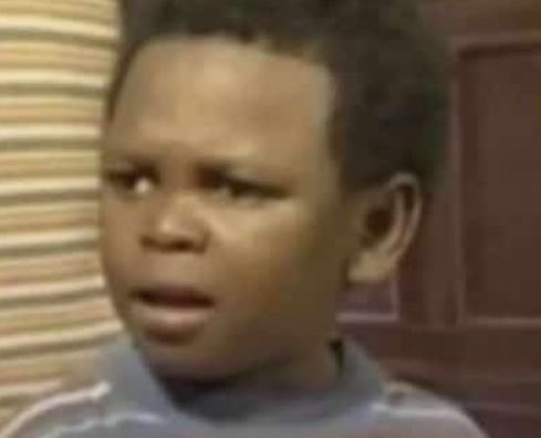 A close-up, slightly blurry photo shows a young boy with a skeptical or confused expression.