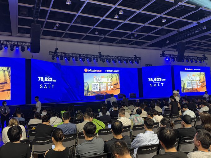 Crowd attending the Bitcoin Asia conference in Nashville, with large screens displaying '78,623 USD SALT' and 'Claim Your SALT' alongside Bitcoin logos.
