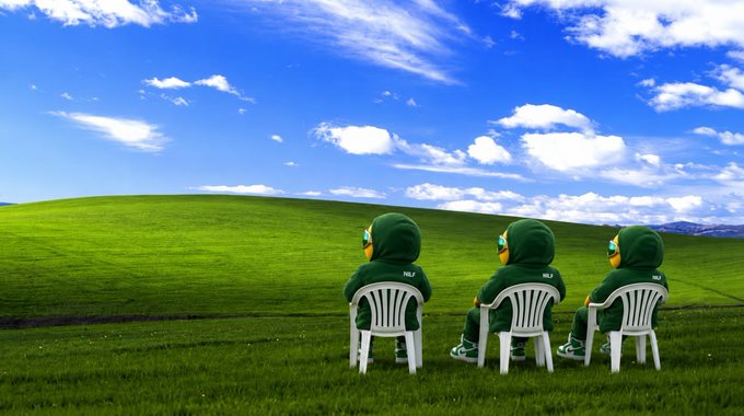 Three figures wearing green hooded outfits sit on white plastic chairs facing a green grassy hill under a blue cloudy sky, in what appears to be a parody of the Windows XP Bliss wallpaper.