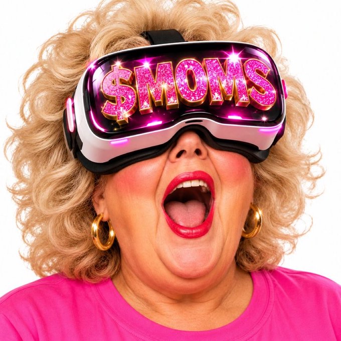 A woman with curly blonde hair and a shocked expression wears a VR headset displaying the text '$MOMS' in sparkly pink letters.