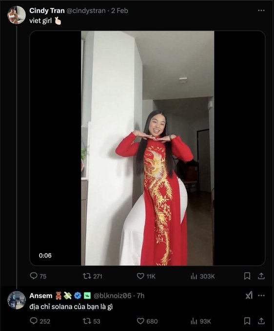 The image is a screenshot of a Twitter/X exchange where Cindy Tran (@cindytran_) posts a 0:06 video of herself in a red traditional Vietnamese áo dài with gold dragon embroidery, posing with a peace sign. Below it, user Ansem (@blknolz06) replies in Vietnamese "địa chỉ solana của bạn là gì" (meaning "what is your solana address"), connecting to the post's theme of Solana memecoins by playfully soliciting her wallet address.