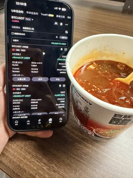 The image shows a cell phone with an open recipe app displaying instructions for making instant noodles, accompanied by a cup of instant noodles placed next to it. The text in the image seems unrelated to the discussion surrounding Bitcoin or any cryptocurrency, and instead focuses on cooking instant noodles using an Asian-inspired recipe from the app's user interface.