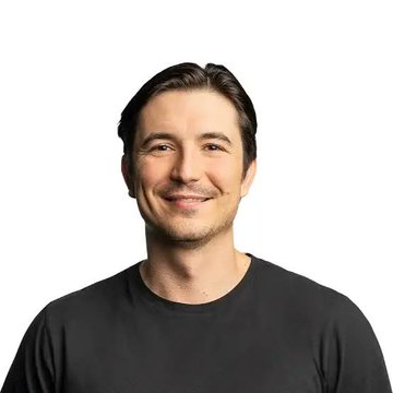 A man with dark hair, wearing a black t-shirt, smiles at the camera against a white background. The image appears to depict Robinhood's CEO, contextualizing his quote about building the Robinhood chain for both real-world assets (RWA) and memes in the crypto space.