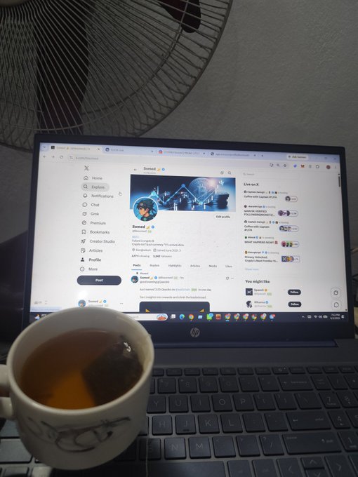 A laptop computer with an open social media page displaying a profile picture of a person, along with a cup of tea next to it. The post features a quote from X Legend that says "Good Night X legend! Everyone falls asleep, Only a few feelings stay awake."