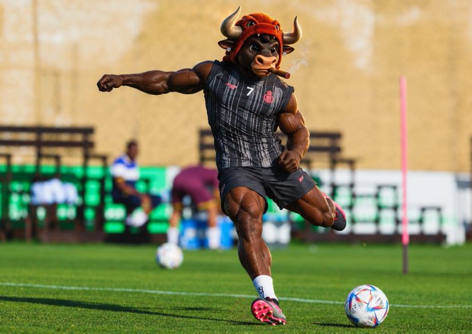 A mascot character dressed as a muscular bull wearing a red and black striped athletic uniform kicks a soccer ball on a field during a training session.