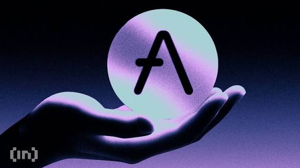A 3D illustration of a glowing hand holding a sphere with the letter 'A' on it, with the BeInCrypto logo in the bottom left corner.