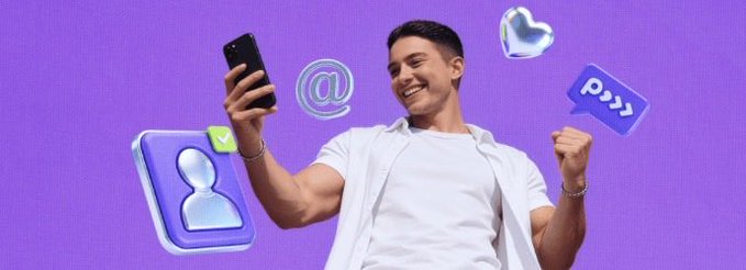 A smiling man in a white shirt takes a selfie with his phone against a purple background, surrounded by 3D social media icons including an '@' symbol and chat bubble.