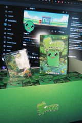 A promotional display featuring a green cartoon mascot on trading card-style boxes and posters in a store setting.