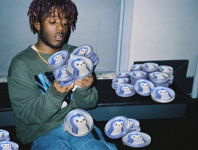 A young man with dreadlocks wearing a green shirt, holding multiple round containers decorated with a cartoon penguin design.