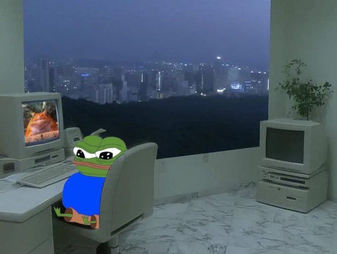 A Pepe the Frog character wearing a blue shirt sits in an office chair at a vintage computer desk, with a large window showing a city skyline at dusk in the background, and a retro Mac computer and potted plant to the right.