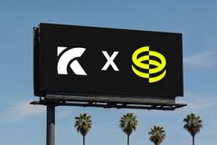 A billboard displaying two logos side by side, appearing to show a collaboration between a K-shaped logo and a green hexagonal symbol, with palm trees visible below.