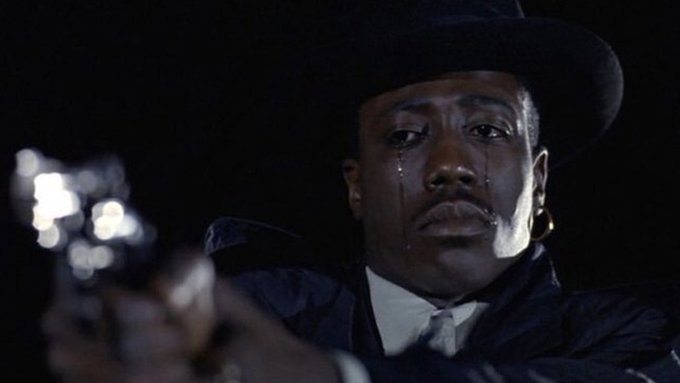A man in a cowboy hat is shown crying while pointing a gun at the camera. The image evokes a sense of desperation and fear, mirroring the post's anxious plea for the $GME stock price not to revisit the low of $17.70.