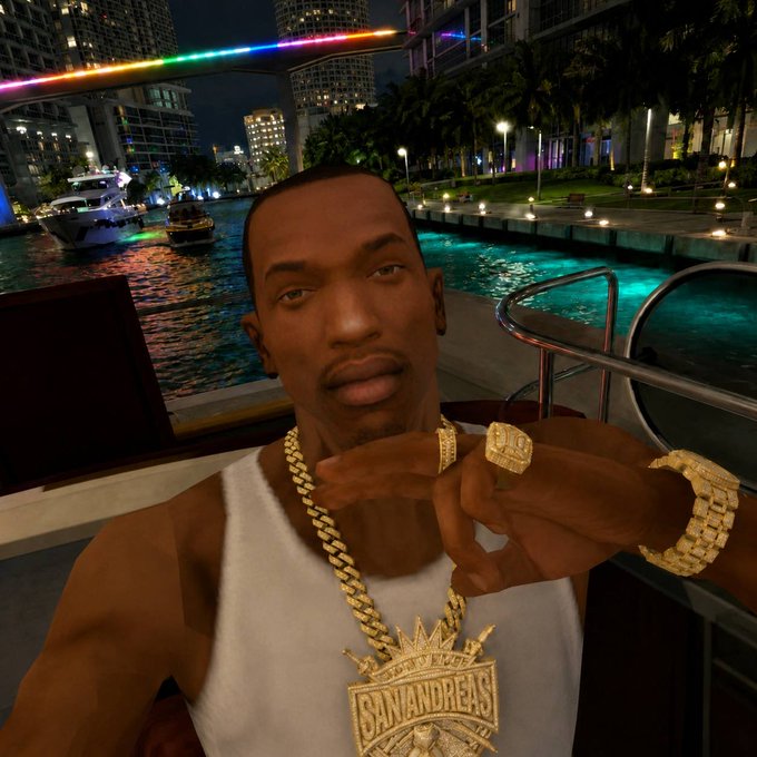 A digital rendering of the CJ character from Grand Theft Auto: San Andreas poses in front of the iconic Grove Street sign and Los Santos cityscape, now wearing a large gold "SANANDREAS" medallion to promote the San Andreas memecoin, blending nostalgic gaming culture with crypto branding.