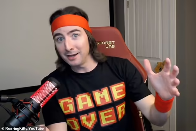 A YouTuber/streamer wearing a red headband and a black 'GAME OVER' t-shirt, sitting in a 'SECRET LAB' chair with a red-lit microphone in front of him; watermarked '© RoaringKitty YouTube'.