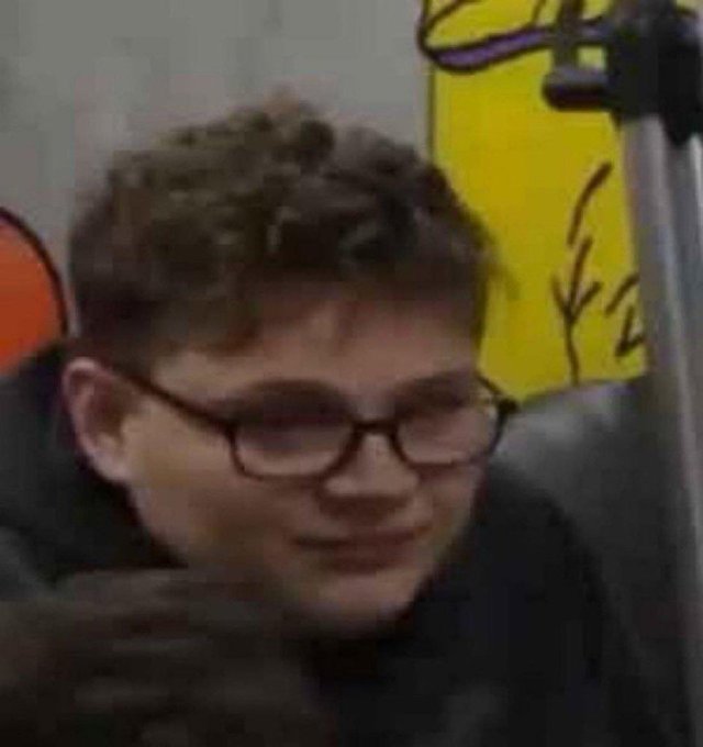 A grainy photo of a young man with curly hair and glasses, appearing to be a reaction meme image.