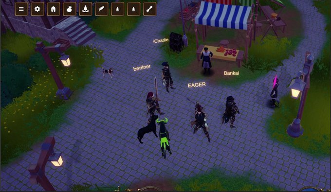 A screenshot from the online multiplayer game "Ansem.io" shows several player characters gathered in a town square with a market stall, displaying usernames like "Charlie," "berliner," "EAGER," and "Bankai." The scene illustrates the gameplay community preparing for the upcoming listing of the "$Patriots" token and a test day for Discord members to participate in the game.